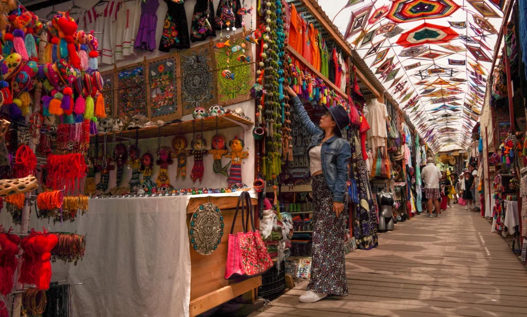 A covered market alley hung with coloured paper banners and craft stalls.