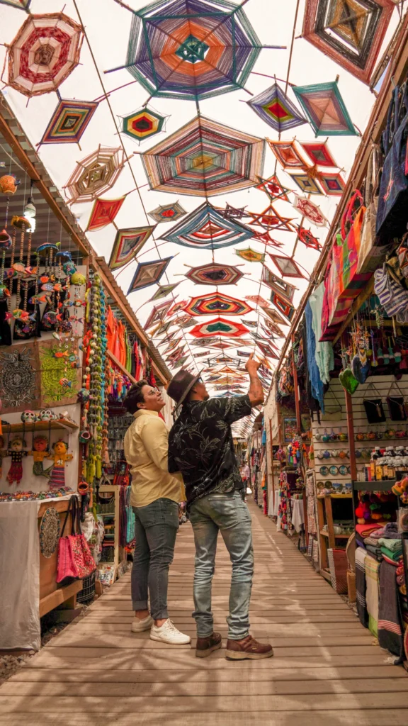 A long covered arcade lined with craft stalls under a patterned ceiling.