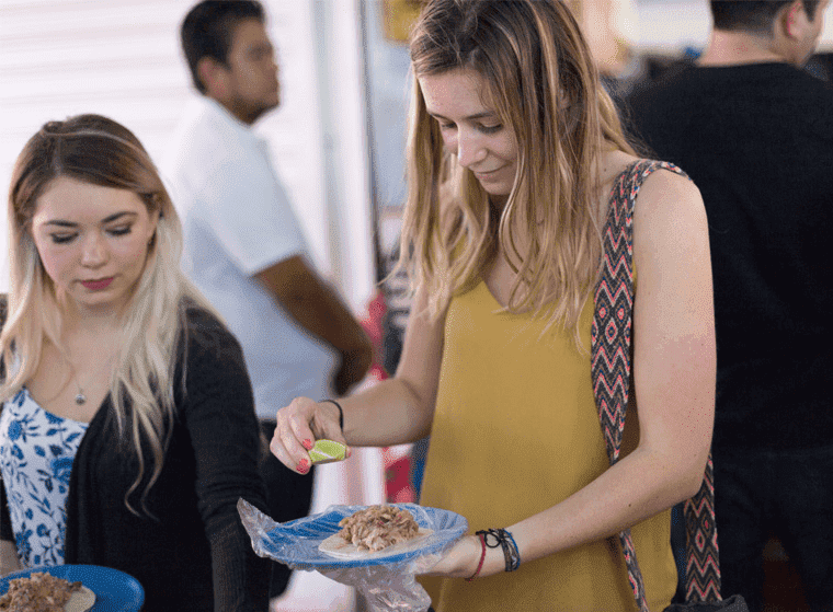 Tour guests being served food at a street-food stop in downtown Cancún