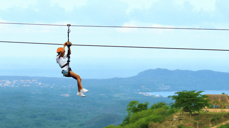 Zip-liner over the jungle with the ocean and coastline behind