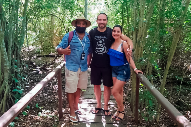 A guide and two hikers on a wooden boardwalk through the dry forest of Huatulco National Park