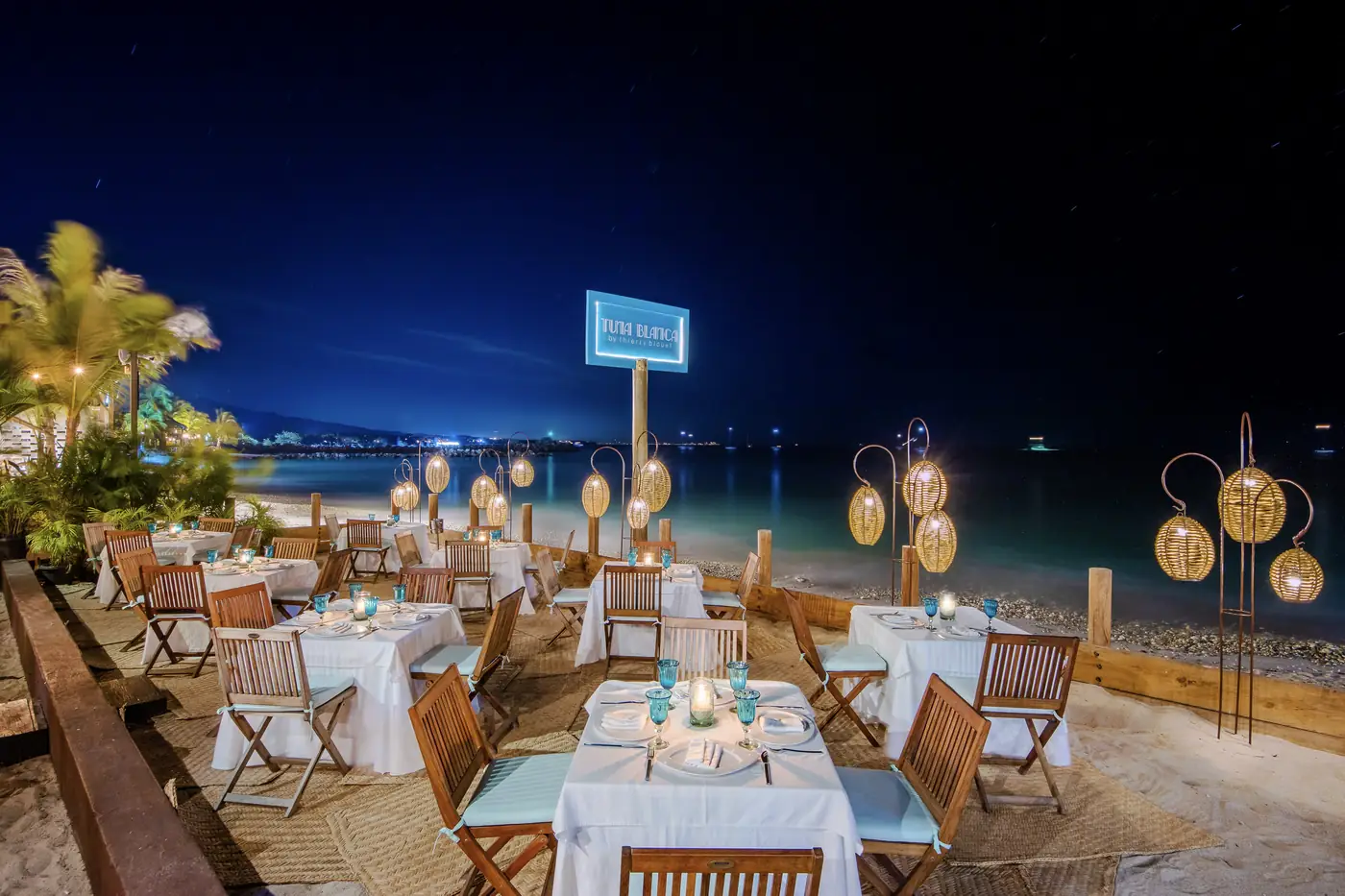Tuna Blanca's tables on the sand at El Anclote beach, Punta de Mita, lit at night