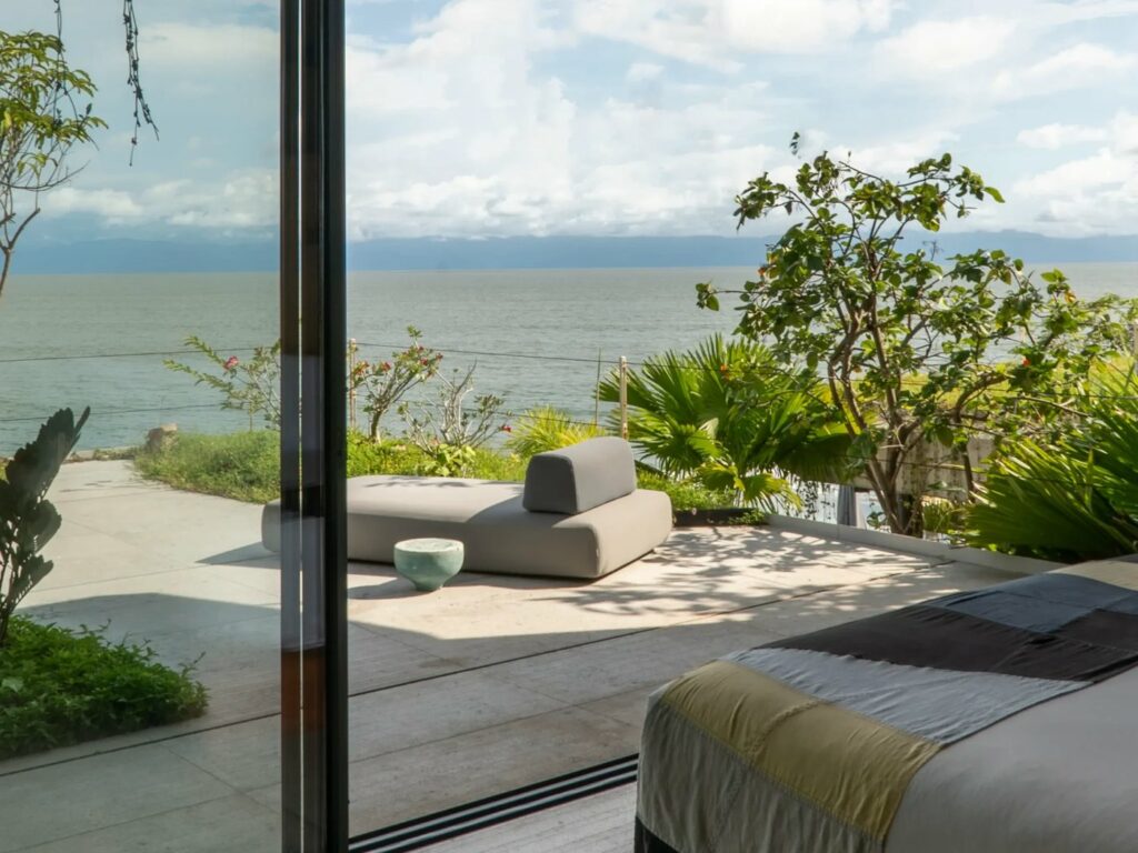 Bedroom opening onto a sea-view terrace with a daybed at Casa Valhalla