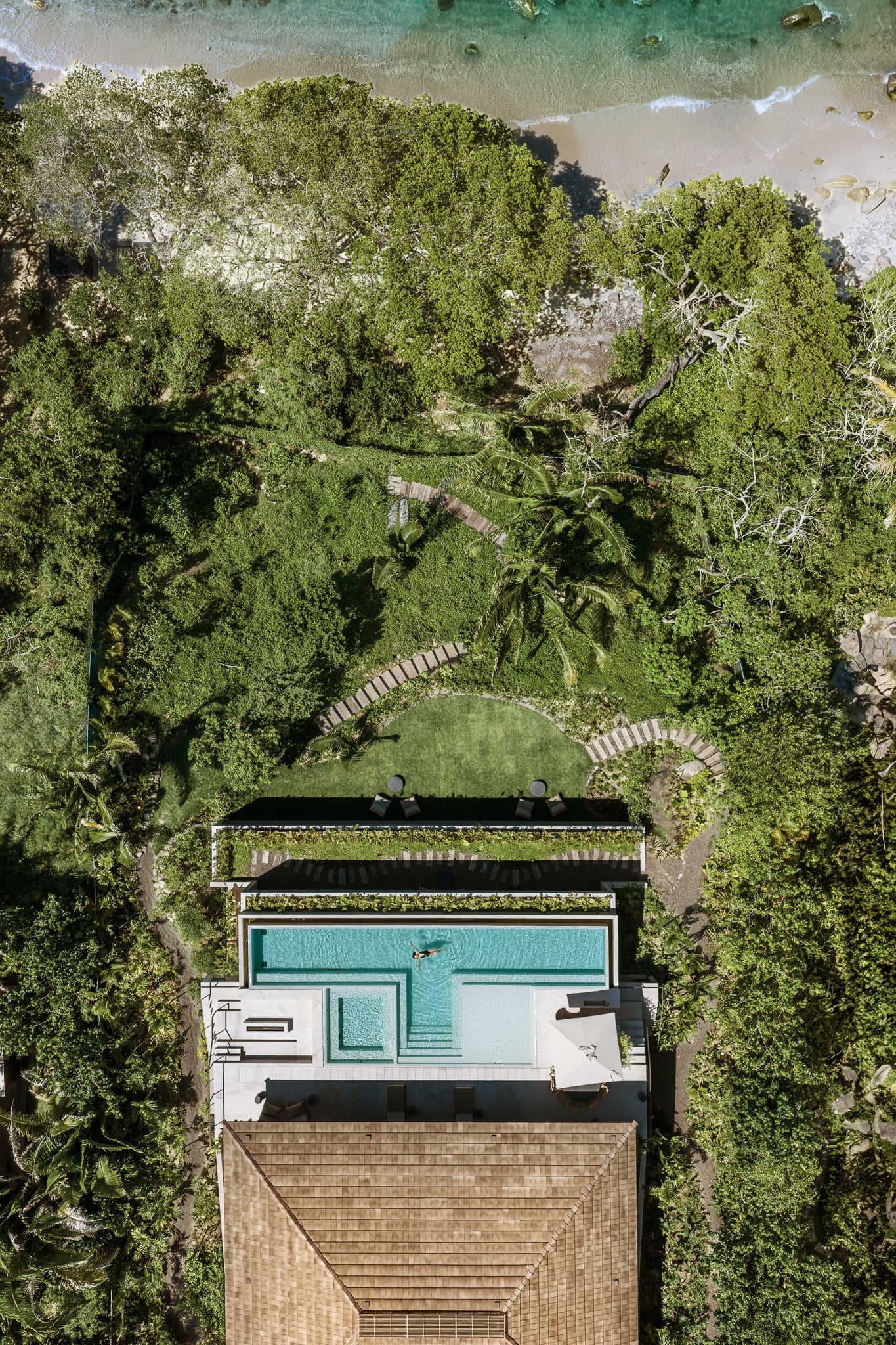 Villa Taiyari from directly above: the roof, the pool and the lawn, with the garden running down to the beach — Punta Mita Nayarit, Mexico
