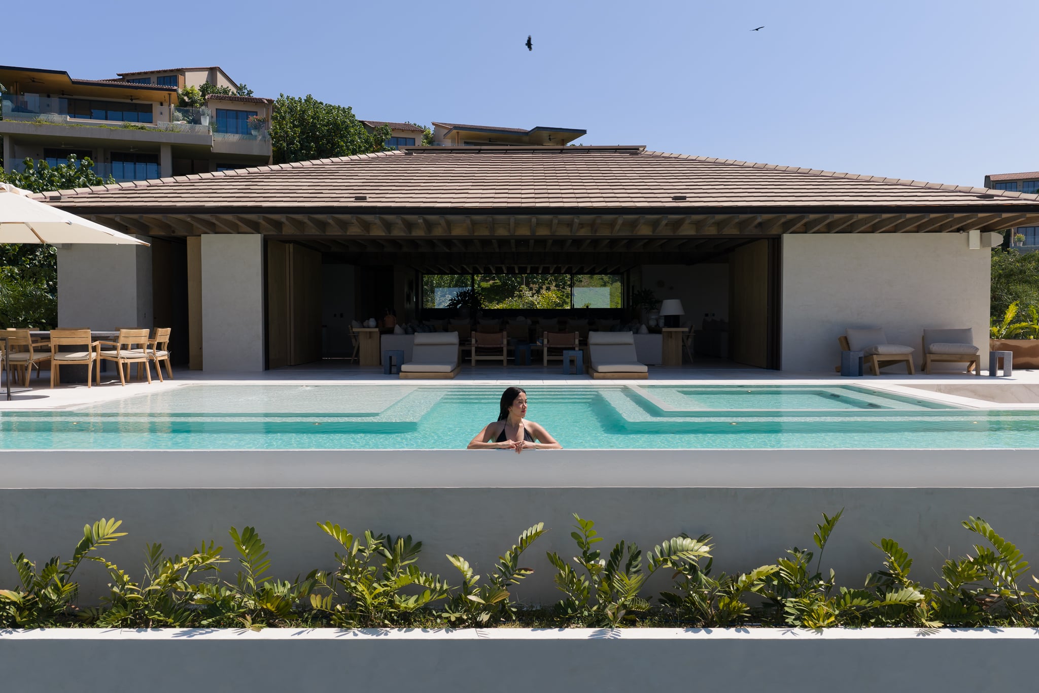 Villa Taiyari pool before the open-sided living pavilion, with loungers and a table under an umbrella — Punta Mita Nayarit, Mexico