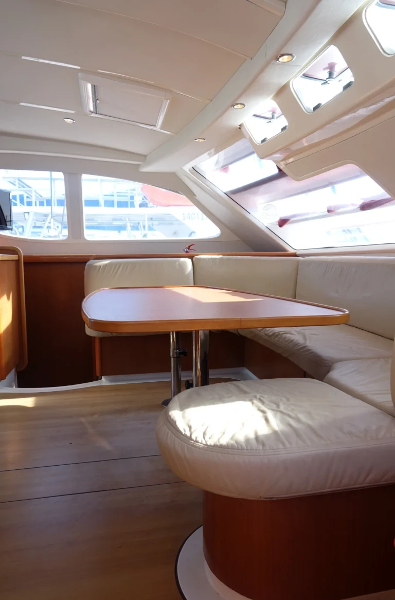 The bright saloon of a sailing catamaran with a table and wide windows.