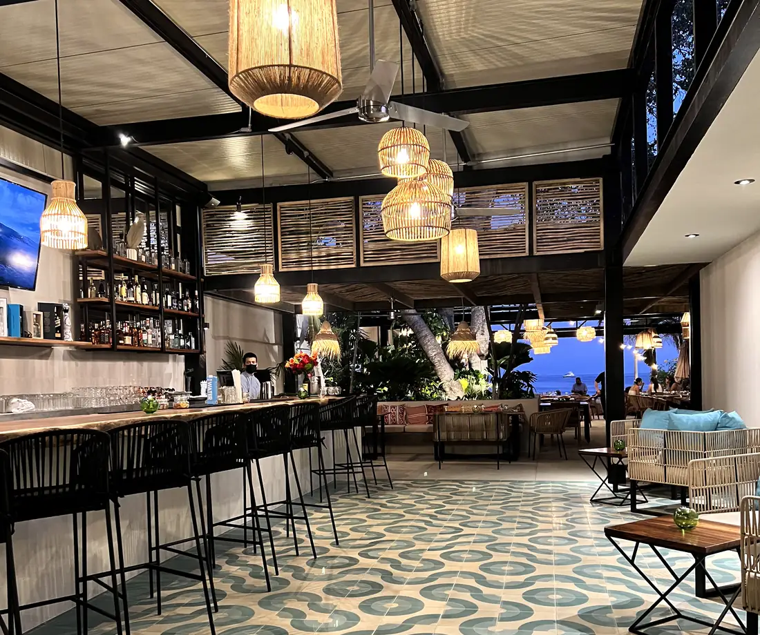 Zicatela's bar and dining room with a patterned tile floor and woven lamps, Punta de Mita